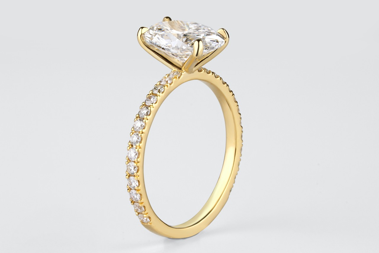 A yellow gold side stone engagement ring with a radiant cut center stone