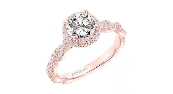 A rose gold engagement ring with a round cut center stone, intertwining bands with a halo and side stones