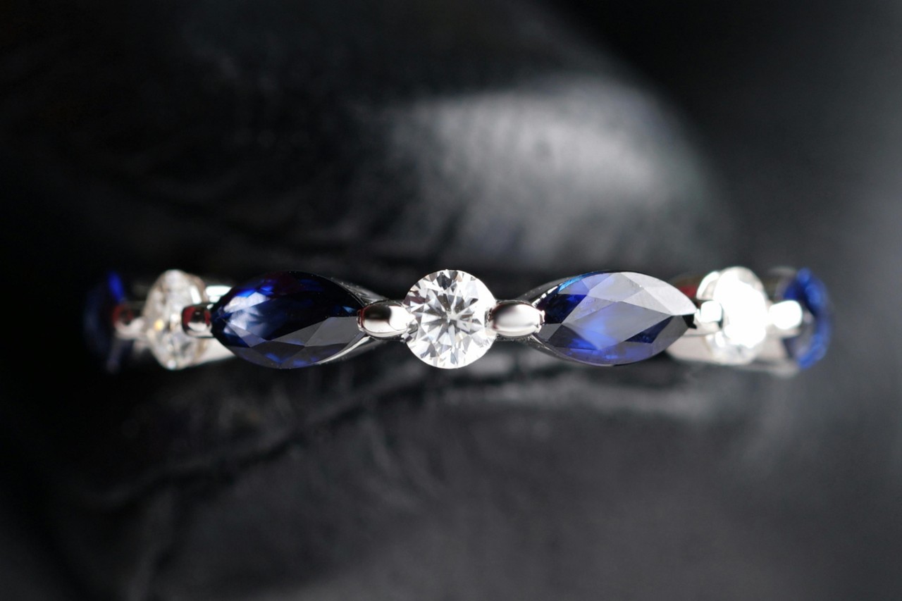 close up image of a diamond and sapphire wedding band