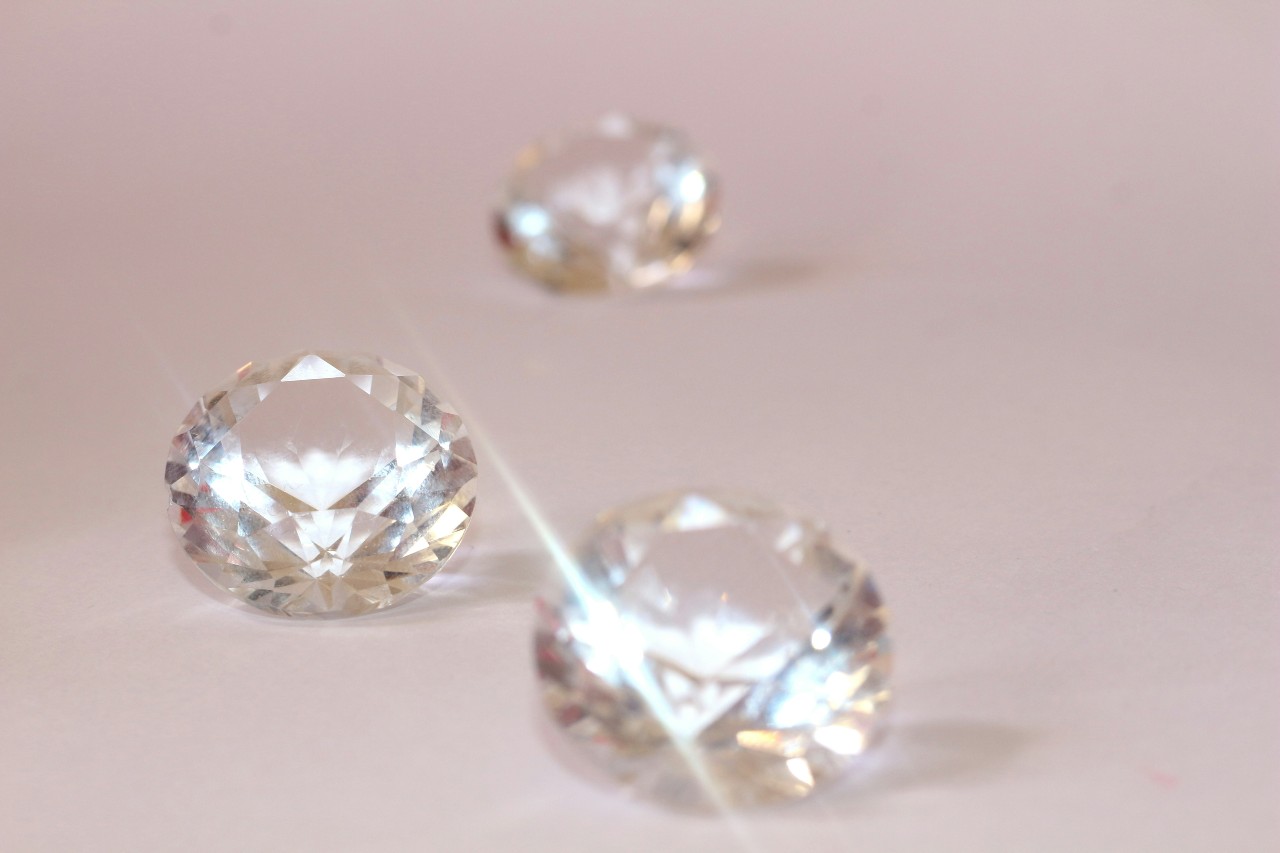 three round cut diamonds lying on a beige surface