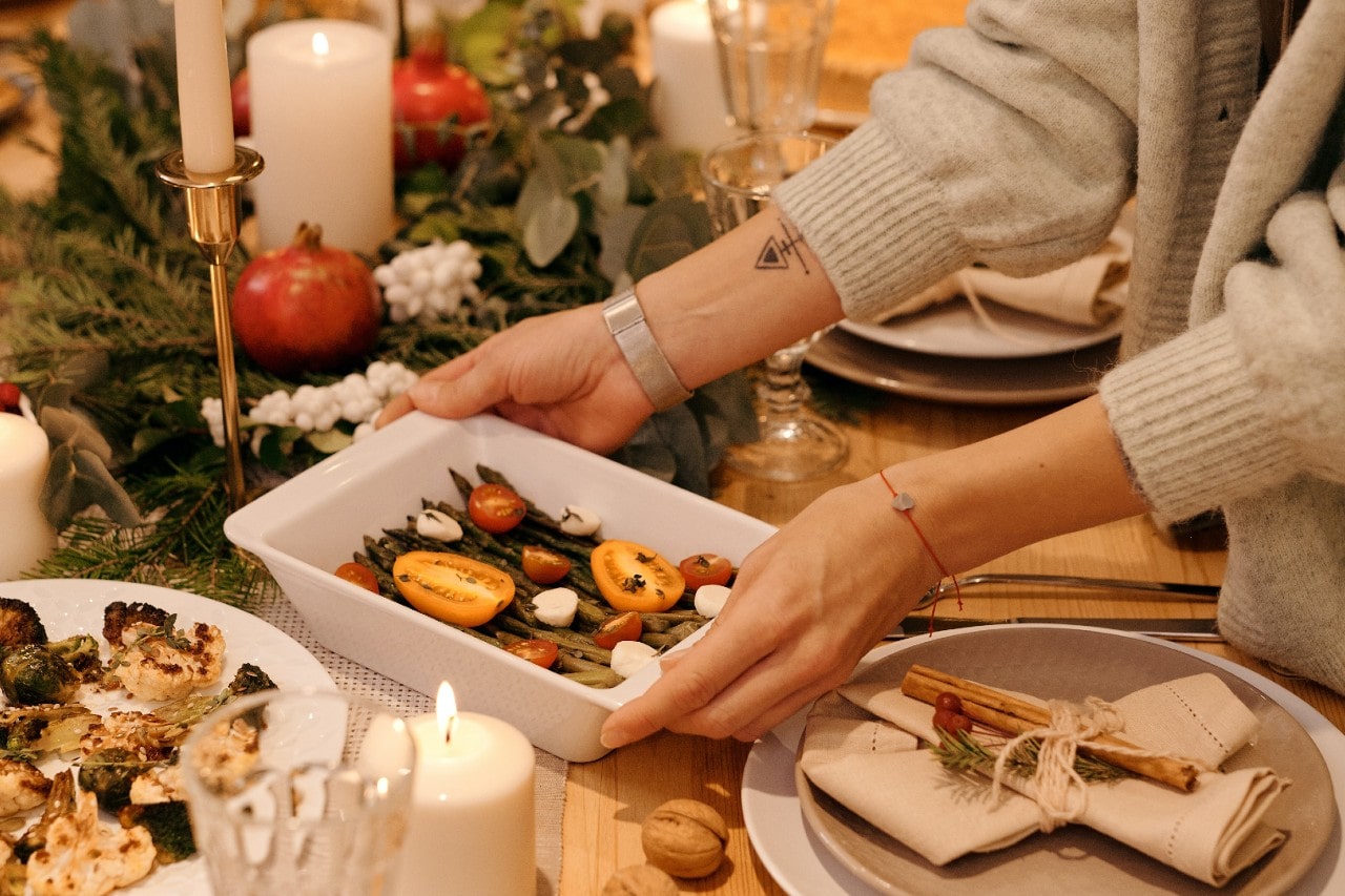 A close-up of a person serving food at Thanksgiving, wearing two elegant bracelets.