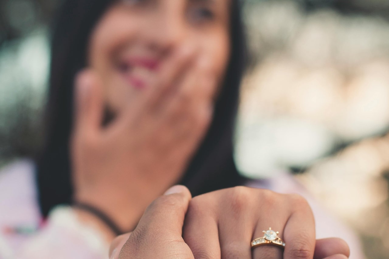 A woman excited after a proposal with a custom engagement ring