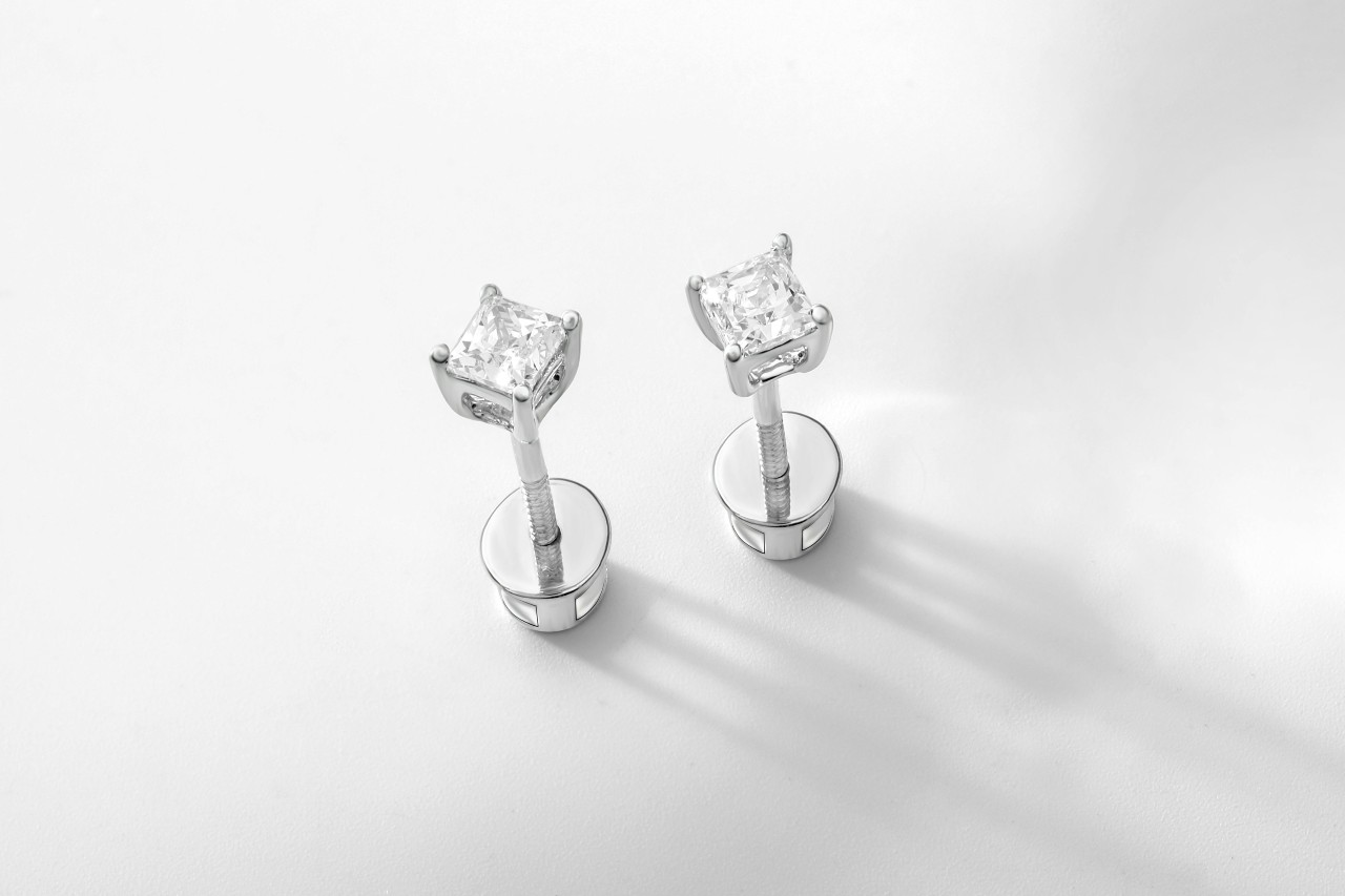 a pair of white gold princess cut diamond stud earrings