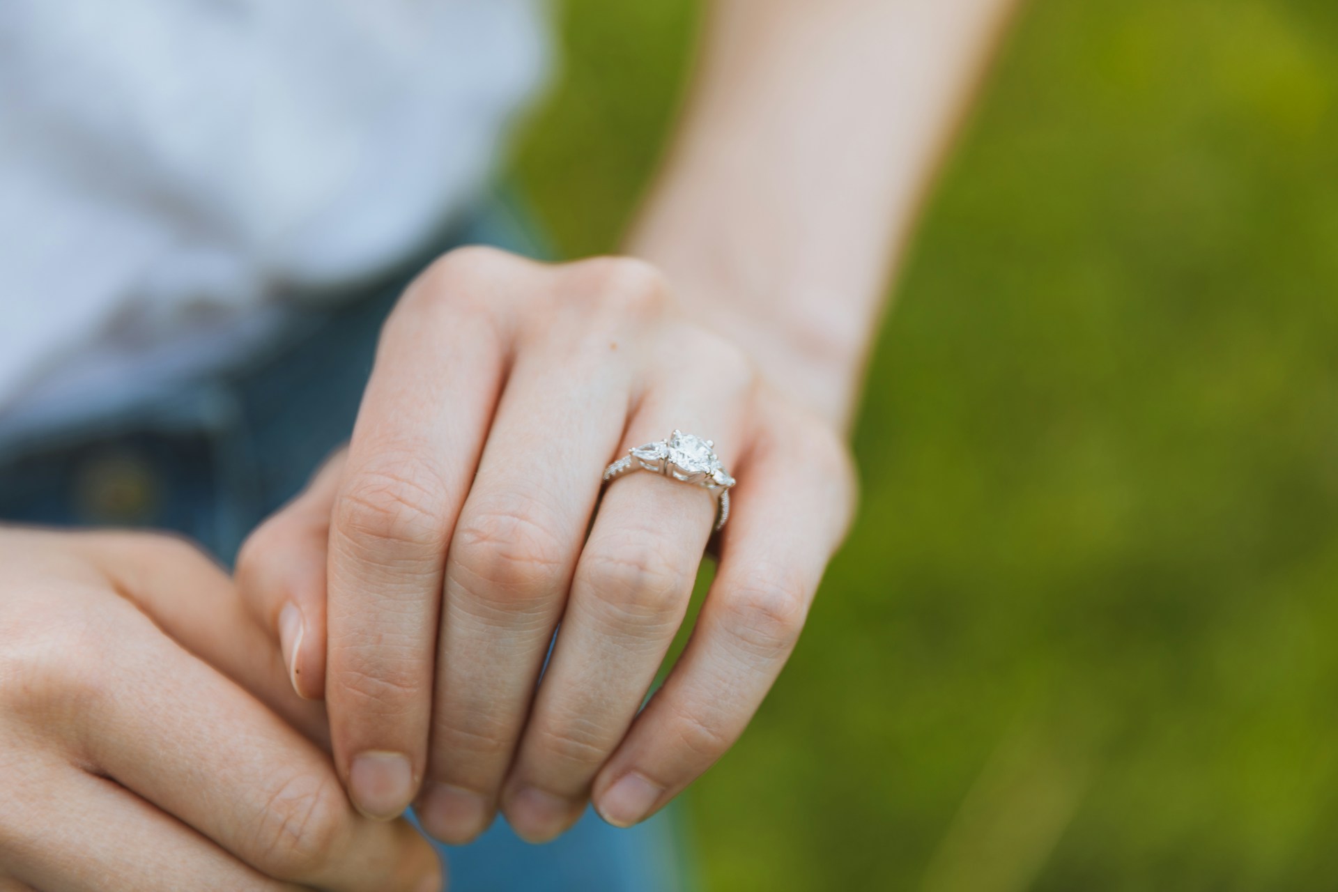 a lady’s hand wearing a diamond engagement ring