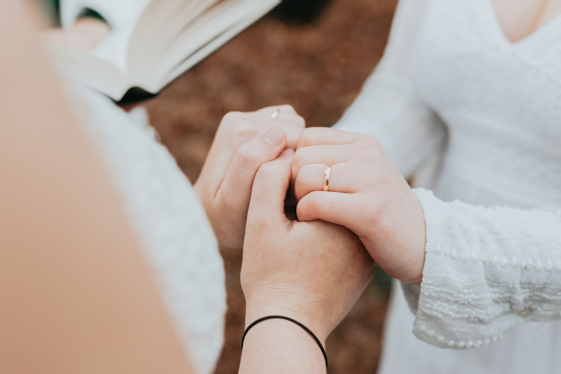 a couple holding hands and showing their wedding bands