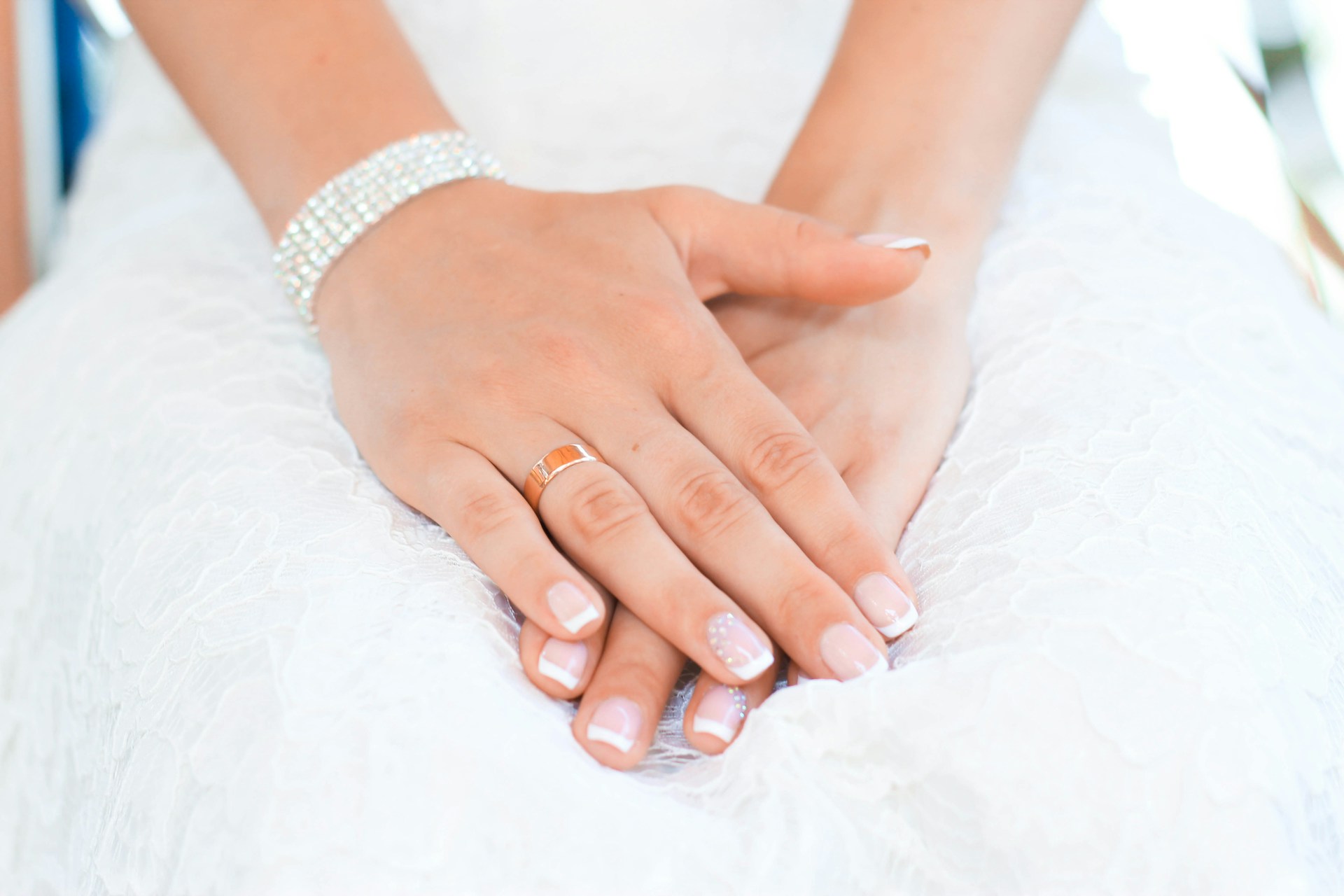 a lady’s hands crossed and wearing a diamond bracelet