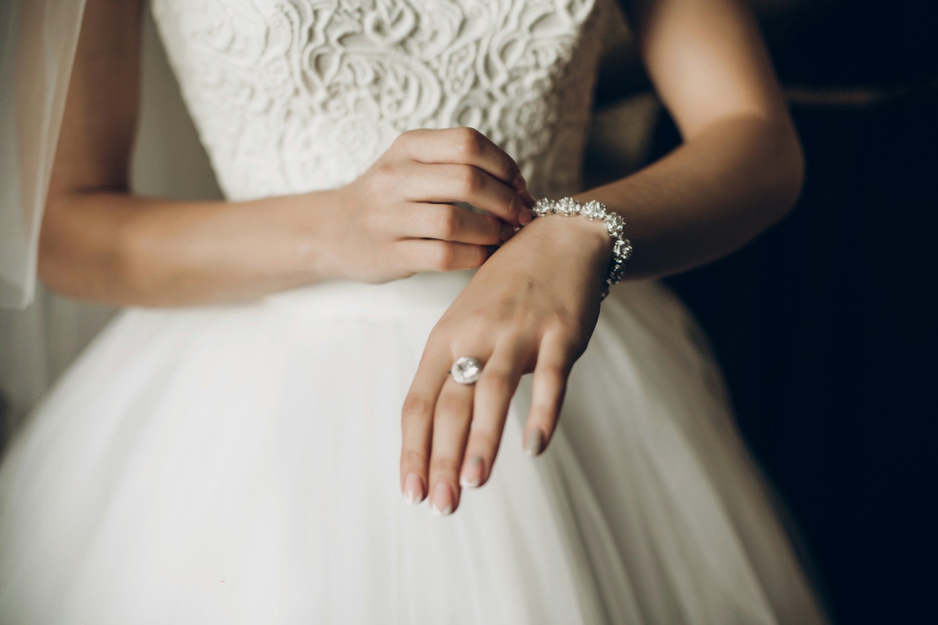 a bride putting on a diamond bracelet