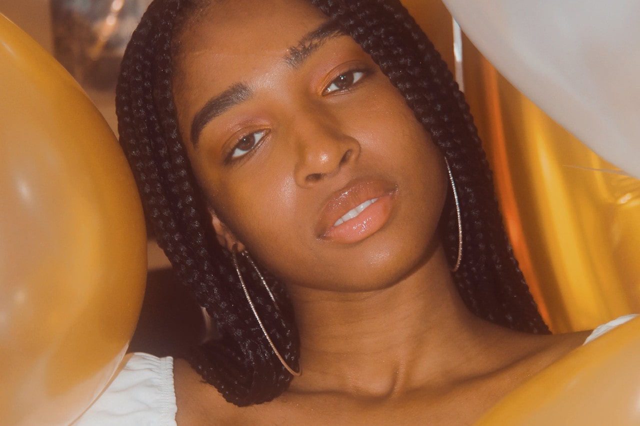 A woman at a party wearing diamond hoop earrings.