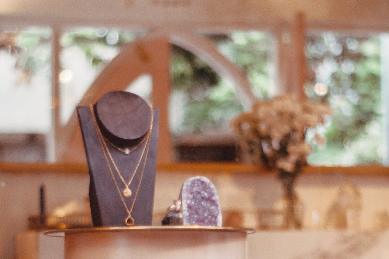 A warmly lit jewelry showroom, with elegant necklaces on display.